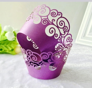 Detail of laser-cut pearlescent purple cupcake wrappers with vintage vine hollow pattern