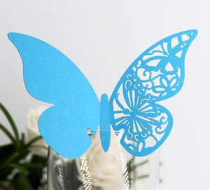 Détail de carte papillon bleu ciel découpée au laser avec motifs floraux ajourés délicats