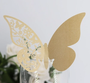 Vue macro d'un marque-place papillon doré pailleté découpé au laser pour verre