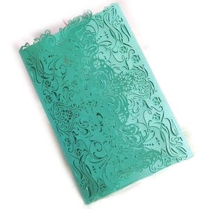 Elegant laser-cut mint green wedding invitation card with intricate floral scroll patterns