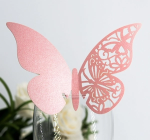 Détail d'un papillon en papier rose découpé au laser pour décoration de bord de verre