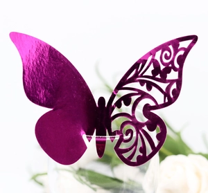 Detailed view of a purple metallic hollow butterfly place card on a wine glass rim