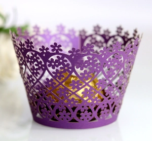 Detail of purple laser-cut cupcake wrapper with floral patterns and gold chocolate
