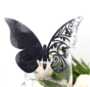 Detail of silver laser-cut butterfly wine glass card with floral hollow pattern