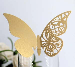 Macro view of gold butterfly decorative cup card with laser-cut hollow pattern and glitter