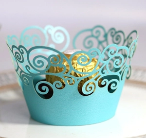 Close-up of laser-cut cupcake wrapper in light blue with intricate scroll lace patterns