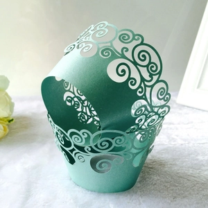 Macro detail of laser-cut mint green cupcake liners with intricate filigree patterns