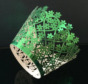 Detailed laser-cut floral cupcake wrapper in glossy metallic green for party decoration