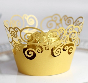 Detail of gold laser-cut hollow lace cupcake wrapper for wedding dessert decor