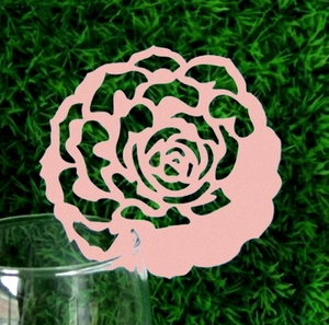 Pink laser-cut rose paper card placeholder on a glass rim for wedding table decor