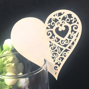Detail of laser-cut heart wine glass card with elegant vine patterns on cream cardstock