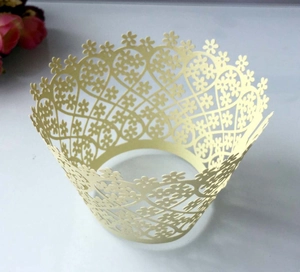 Detailed laser-cut heart and floral pattern on champagne paper cupcake wrappers
