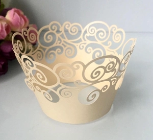 Detailed laser-cut hollow pattern on off-white cupcake wrapper for wedding decor