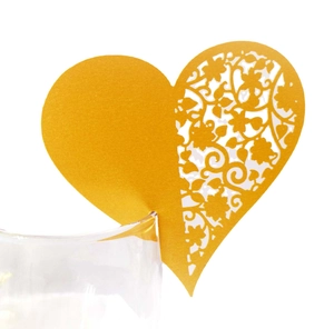Golden heart-shaped wine glass place card with intricate laser-cut floral patterns