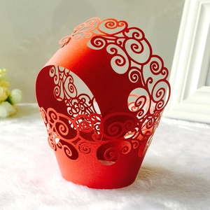 Close-up of laser-cut red cupcake wrapper with intricate cloud patterns on white fur