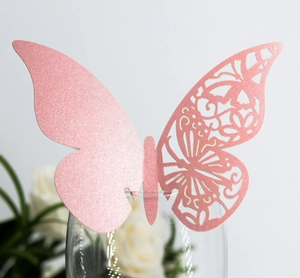 Close-up of pink glitter laser-cut butterfly card for wedding glass decoration