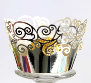 Macro view of silver laser-cut cupcake wrappers with elegant scroll patterns