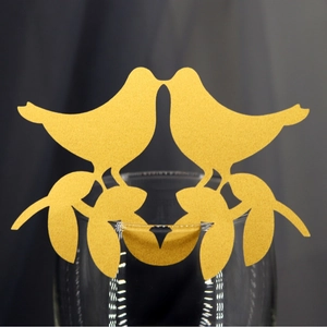 Golden laser cut bird place cards for wedding glasses with sparkling pearlescent finish