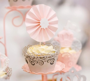 Macro shot of laser-cut cupcake wrappers with elegant scroll patterns in Morandi tones