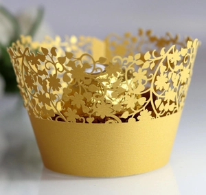 Elegant gold laser-cut floral cupcake wrapper with intricate vine pattern for wedding decor