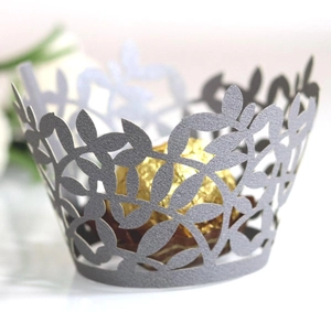 Macro shot of laser cut silver leaf cupcake liner wrapped around golden truffle