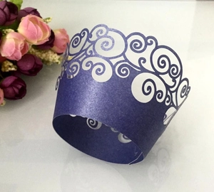 Deep purple laser-cut cupcake wrappers with intricate swirl pattern and pearlescent finish