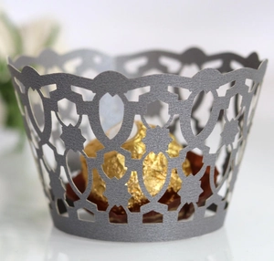 Macro view of laser-cut hollow cup coaster with silver floral pattern for dessert decor