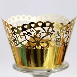Elegant gold laser-cut lace cupcake wrappers with intricate floral vine and heart patterns