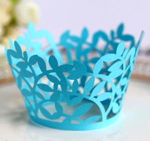 Macro detail of laser-cut blue cupcake wrappers with elegant leaf hollow patterns