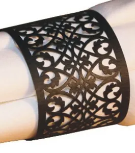 Elegant black laser-cut paper napkin ring with intricate vine patterns on white napkin