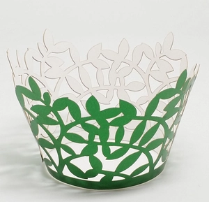 Detail of laser-cut cupcake wrappers with green leaf patterns and vine textures