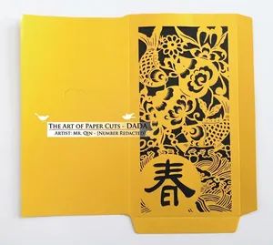 Laser cut yellow paper envelope with intricate black koi and floral spring pattern