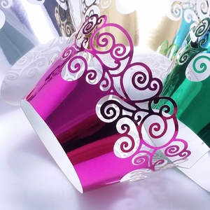 Laser cut cupcake wrappers with metallic finish and intricate swirl patterns in various colors