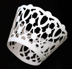 Macro shot of white laser-cut lace cupcake wrappers with elegant hollowed-out patterns