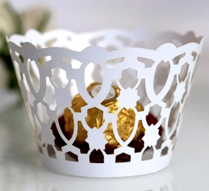 Elegant white laser-cut cupcake wrappers with geometric patterns for party decoration