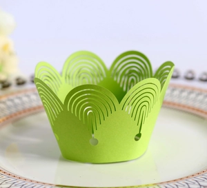 Macro view of laser-cut light green cupcake wrapper with elegant crown patterns