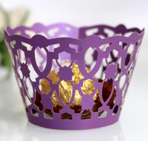 Purple laser-cut lace cupcake wrappers with elegant geometric patterns for party decor