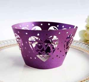 Purple laser cut heart lace cupcake wrappers with LOVE pattern on white ceramic plate