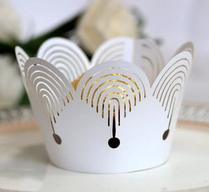 Detailed view of laser-cut white cupcake wrapper with elegant crown hollow design