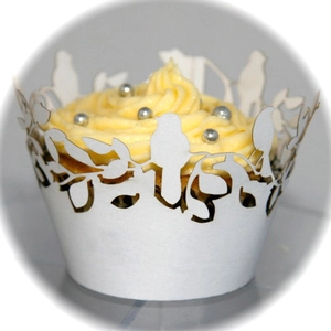 Detailed laser-cut bird and tree branch pattern on white lace cupcake wrapper