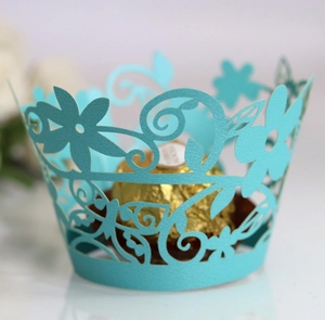 Macro detail of laser-cut light blue cupcake wrapper with elegant floral vine hollow pattern