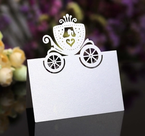 Intricate laser-cut pumpkin carriage place card on white pearlescent paper for weddings