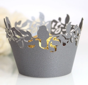 Detail of laser-cut bird pattern on pearl grey cupcake wrapper with shimmer texture
