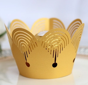 Close-up of laser-cut gold crown cupcake wrapper and decorative chocolate liner