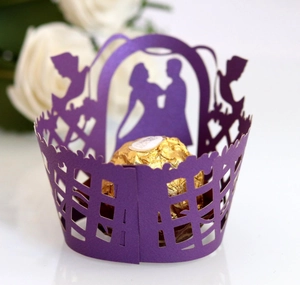 Detail of purple laser cut cupcake wrapper with heart and couple silhouette pattern