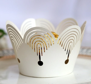 Macro view of white laser-cut paper cupcake wrappers featuring elegant wavy edge patterns