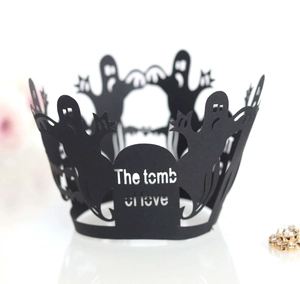 Detail of black laser-cut cupcake wrappers with Halloween ghost and tomb of love motifs