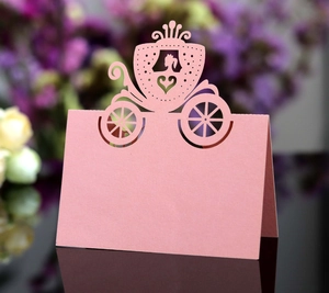 Detail of pink laser-cut princess carriage place card for wedding reception tables