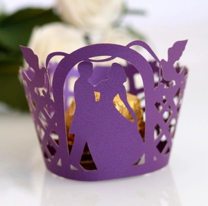 Detail of dark purple laser cut cupcake wrapper with wedding silhouette and bird pattern