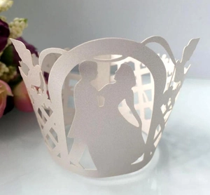 Detail of laser-cut pearl white cupcake wrapper featuring a romantic bridal couple silhouette